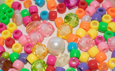 Fototapeta na wymiar Beads multi-colored pearl beads for braiding braids braids on a light background for design