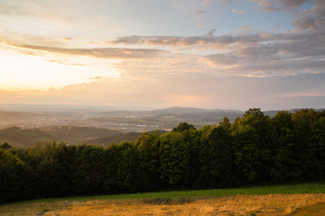 Meadow landscape countryside view with blue sky with many clouds sun light and forest close to city Valasske Mezirici captured during summer late time from hill.