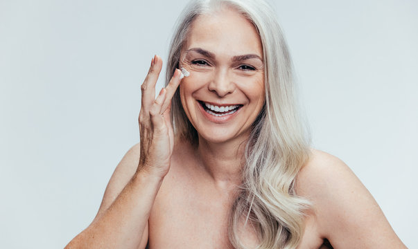 Woman applying anti aging cosmetic