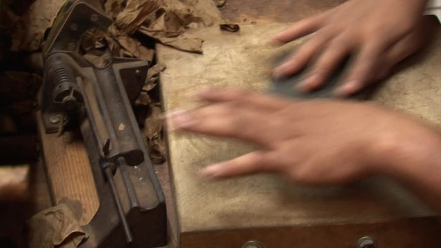 Hand rolling cigar in cigar factory-cuts and finishes making cigar-Miami-Calle Ocho-SW 8th Street-Cuban-American
