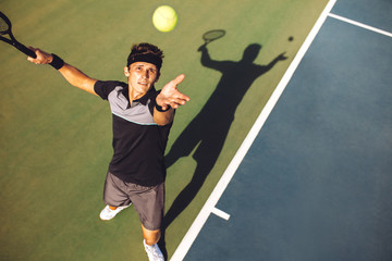 Tennis player serving the ball in a match - Powered by Adobe