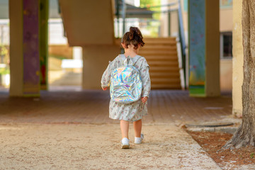 Fototapeta premium Pupil kid going to school with holographic schoolbag or satchel, child walking to school bus. Toddler first day at school or preschool.