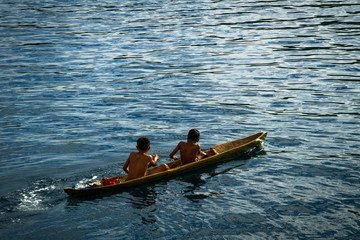 Local fisherman young boys play on the small traditional paddle boat