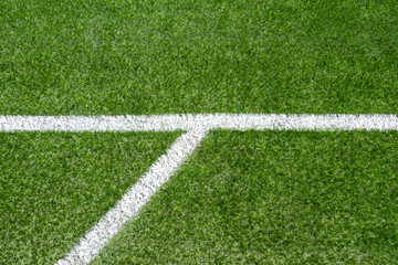 Green synthetic artificial grass soccer sports field with white corner stripe line