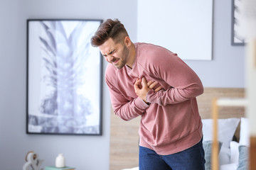 Young man suffering from heart attack at home