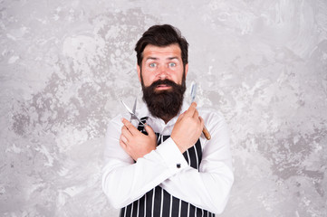 Male beauty. Barbershop master. Maintain stylish shape. Vintage barber. Barber in apron hairdresser equipment blade and scissors. Barber tools. Taking good care facial hair. Bearded hipster shaving