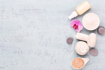 Sea salt, aromatherapy oil in bottles and chamomile on vintage wooden background.