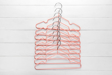 Many clothes hangers on white wooden background