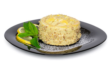 Sponge cake with cottage cheese and lemon cream, decorated with pieces of fruits, ground walnuts, mint leaves and powdered sugar