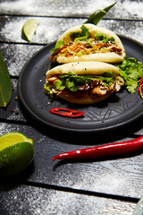 Asian dish on a black plate. Bao with meat and vegetables