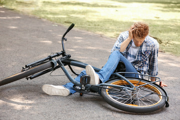 Obraz premium Young man fallen off his bicycle outdoors
