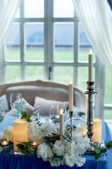 Wedding table decorated with white flowers, candles..Blue and white.
