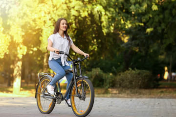 Obraz na płótnie Canvas Young woman riding bicycle outdoors