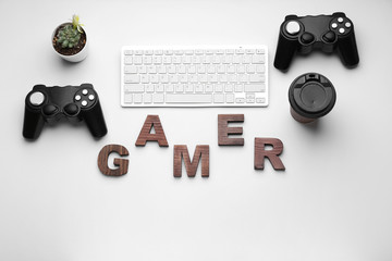 Computer keyboard with joypads, cup of coffee and word GAMER on white background © Pixel-Shot