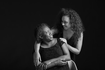 Black and white portrait of African-American woman with her daughter on dark background