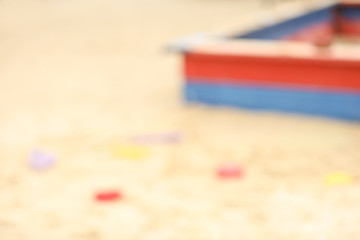 Blurred view on sandpit with toys outdoors