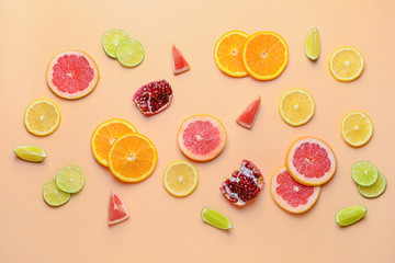 Different sliced citrus fruits on color background