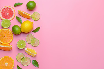 Different sliced citrus fruits on color background