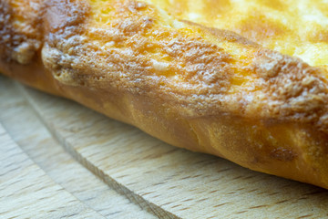 Freshly baked khachapuri with cheese on a wooden board.
