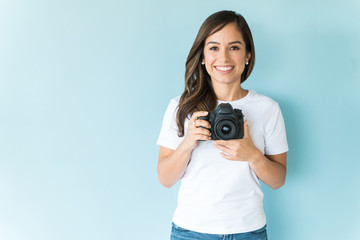 Attractive Woman With Camera In Studio