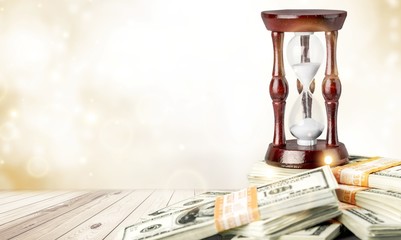 Time And Money Concept image - sand watch and background of money.