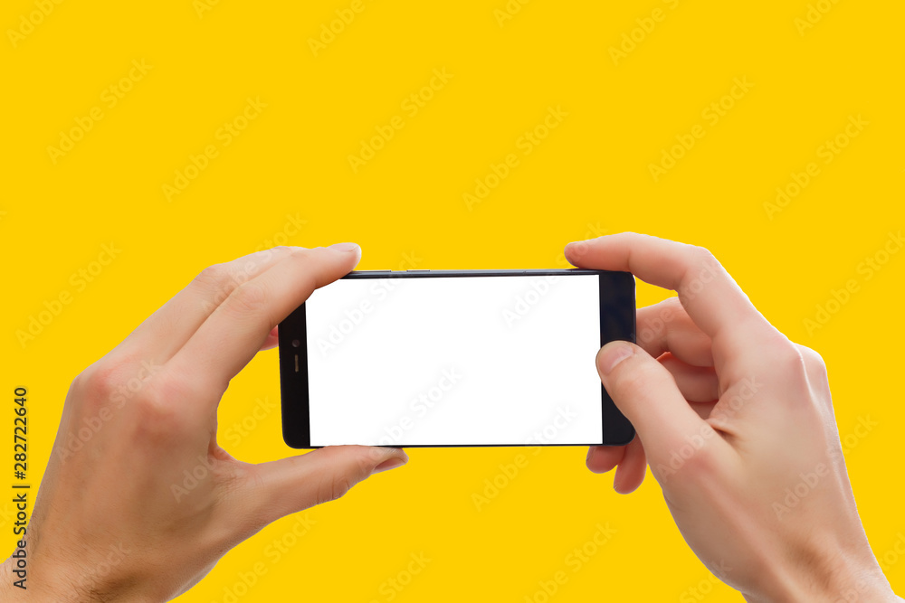 Poster closeup shot typing on mobile phone isolated on orange background.. hand holding a modern smartphone