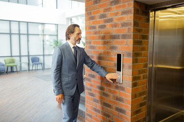 Businessman wearing grey suit and tie standing near elevator