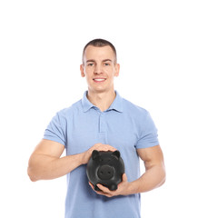 Young man with piggy bank on white background