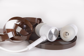White headphones and magnetic tape with call recordings. Eavesdropping accessories.