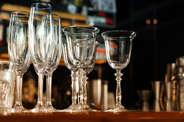 Different empty clean glasses on counter in bar