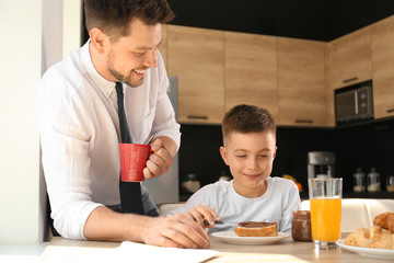 Dad and son having breakfast together in kitchen