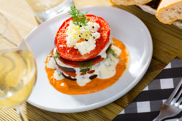 Stack of fried eggplant with tomatoes and piquant sauce