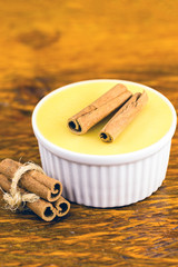 Typical Brazilian dessert, sweet of mingua, called in Brazil of curau. Typical sweet of June party. Brazilian sweet corn, corn mousse on a wooden background with copy space.