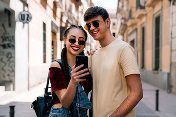 Happy young couple using mobile phone