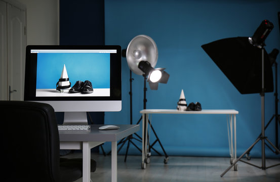 Shooting of men's shoes and belt for product promotion in photo studio, focus on PC screen