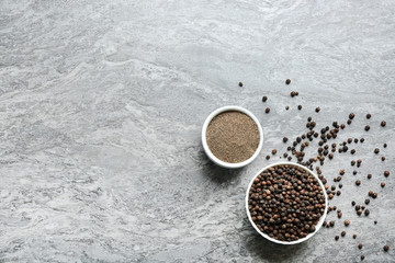 Ground black pepper and corns on grey table, top view. Space for text
