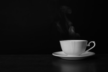 Ceramic cup of hot fresh tea on table against black background, space for text