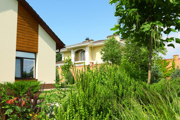 Fototapeta na wymiar Beautiful green garden near modern house on sunny day