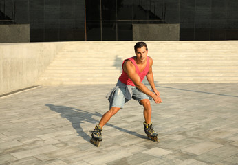 Handsome young man roller skating on city street