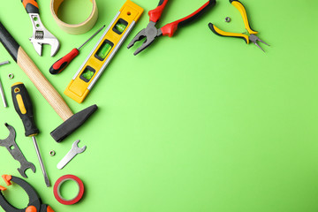 Set of repair tools on light green background, flat lay. Space for text
