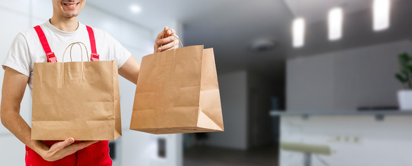 delivery, mail and people concept - happy man delivering food in disposable paper bag to customer home