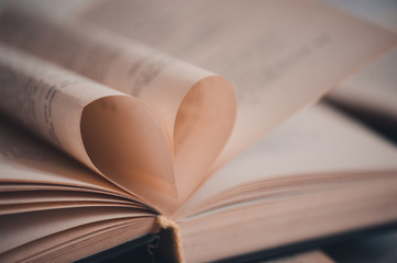 Love concept. Open book floded in heart shape closeup. Valentines Day.