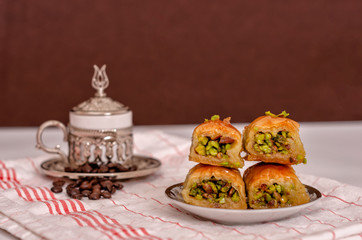 turkish delights - baklava with turkish coffee, coffee beans on the white fabric and brown background