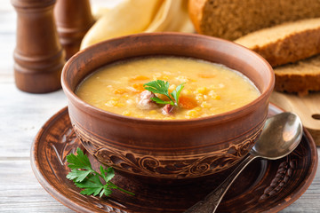 Split pea soup in ceramic bowl on wooden table. Selective focus.