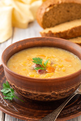 Split pea soup in ceramic bowl on wooden table. Selective focus.