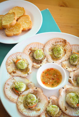 Grilled scallops topped with butter and garlic bread.