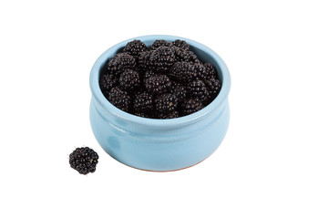 Fototapeta na wymiar Black blackberry in a ceramic bowl on a white isolated background with a separate berry