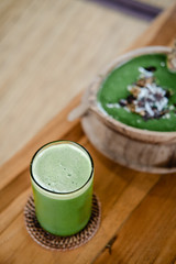 Glass of green celery juice on wooden table