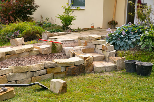 Stone steps and dry stone wall under construction  -   landscaping works with natural stones