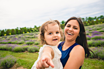 Happy family mother and daughter having fun in lavender field